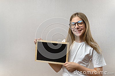 Beautiful mischievous girl with glasses holding a sign in her hands. copy-space Stock Photo