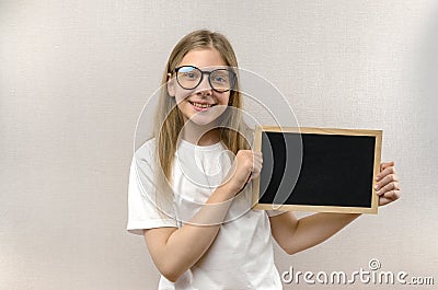 Beautiful mischievous girl with glasses holding a sign in her hands. copy-space Stock Photo