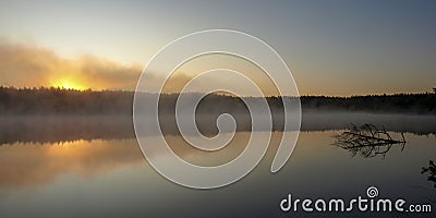 Beautiful mist on the lake, dark tree silhouettes, sunset on the forest lake Stock Photo
