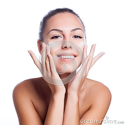 Beautiful model applying cosmetic cream treatment on her face on white Stock Photo