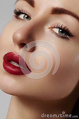 Beautiful model with fashion make-up. Close-up portrait woman with glamour lip gloss makeup and bright eye shadows. Stock Photo