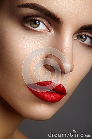 Beautiful model with fashion make-up. Close-up portrait woman with glamour lip gloss makeup and bright eye shadows. Stock Photo