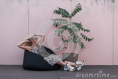 Beautiful model woman with sunglasses in dress with sneakers Stock Photo