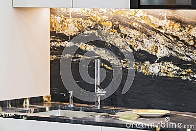 Beautiful modern kitchen design, kitchen faucet, black and gold stone marble countertop kitchen Stock Photo