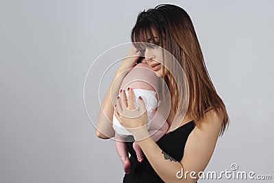 Beautiful mom holding her baby on studio Stock Photo