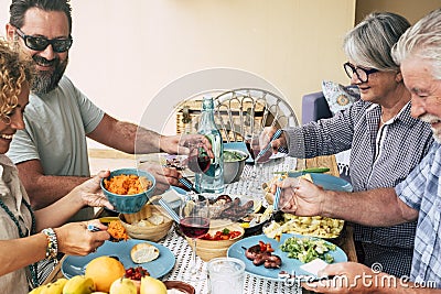 Beautiful moment of family lifestyle at home eating and drinkng food or drinks at home on the table - man with sunglasses tking a Stock Photo