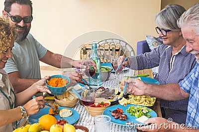 Beautiful moment of family lifestyle at home eating and drinkng food or drinks at home on the table - man with sunglasses tking a Stock Photo