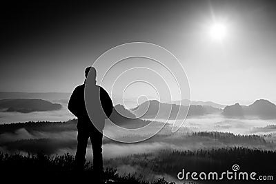 Beautiful moment the miracle of nature. Man stands on the peak of sandstone rock in national park Saxony Switzerland and watching Stock Photo