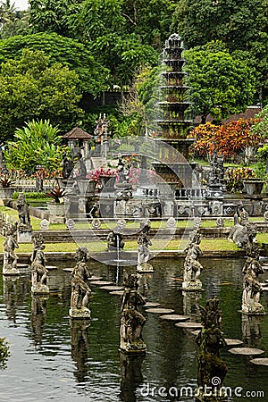 Beautiful monument on indonesian culture and history - Tirta Gangga park with lush green tropical trees, pond, fountain, foothpath Stock Photo