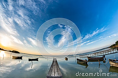 Beautiful morning landscape with boats on the lake anchored to the pier and wood bridges at sunrise Editorial Stock Photo