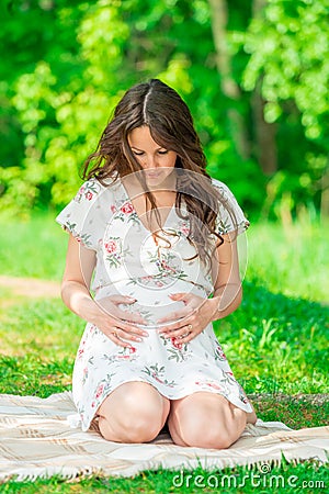 beautiful mother in anticipation of a child, shooting in a summer park Stock Photo