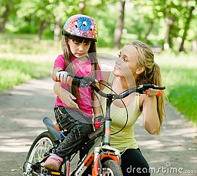 Beautiful mother calms the sad daughter who did not get to ride Stock Photo