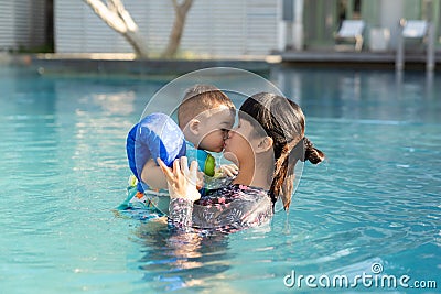 Beautiful mother and cute baby boy happinese in swimming pool Stock Photo