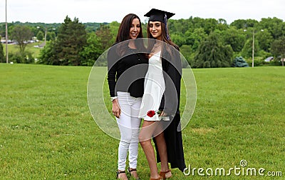 Beautiful mother and daughter in black Cap, Gown and Tass, teenager. Unique gorgeous face, nice smile, wonderful eyes girl. Stock Photo