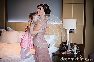 Beautiful mother hugs daughter in the bedroom Stock Photo