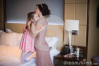 Beautiful mother hugs daughter in the bedroom Stock Photo