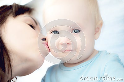 Beautiful mother playing with her beautiful child , the child eats the cookie and laughs Stock Photo