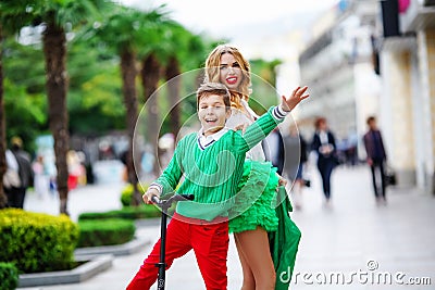 Beautiful mother and son spend active time and ride a scooter together Stock Photo