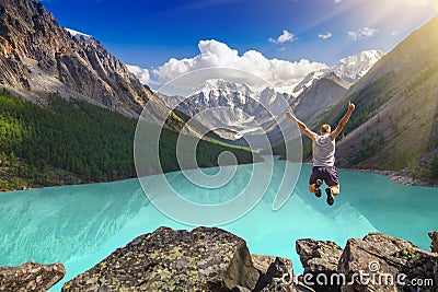 Beautiful mountain landscape with lake and jumping man Stock Photo