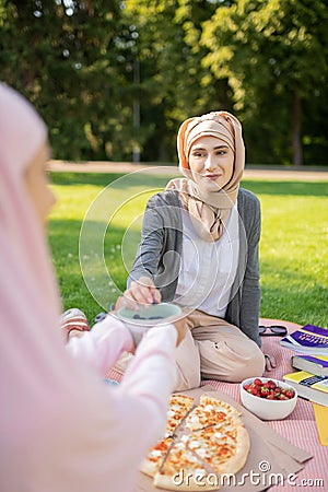 Beautiful muslim woman eating yummy lunch with friend Stock Photo
