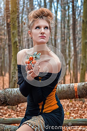 Beautiful mysterious girl in a dress in the autumn forest with tangerine trees Stock Photo