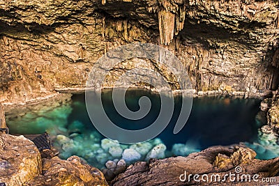 Beautiful natural pool of crystal clear water formed in a rocky cave with stalagmites and stalagmites Stock Photo