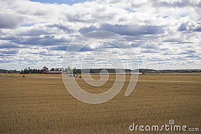 Beautiful nature landscape view of field after harvesting under cloudy summer sky. Stock Photo