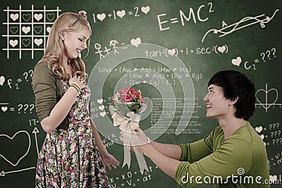 Beautiful nerd girl get flowers in class Stock Photo