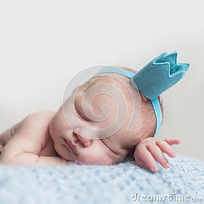 Beautiful newborn baby girl in blue crown, closeup portrait Stock Photo