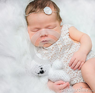 Beautiful newborn girl sleeping on fluffy plaid with toy Stock Photo