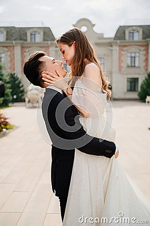 beautiful newlyweds dancing and whirling against the background of a building. Stock Photo