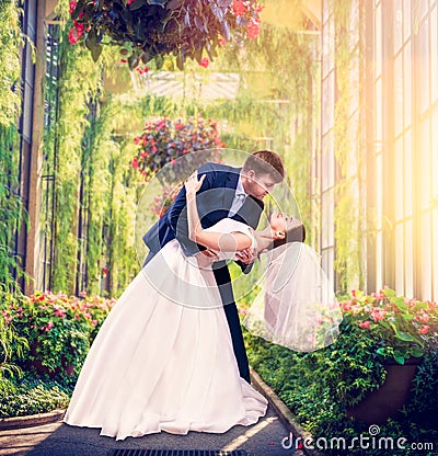 Beautiful newlyweds embrace in a green garden Stock Photo