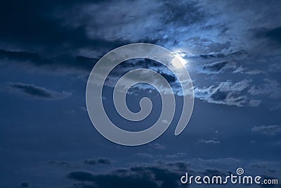 Beautiful night sky. The full moon illuminates clouds. Nature background. Stock Photo