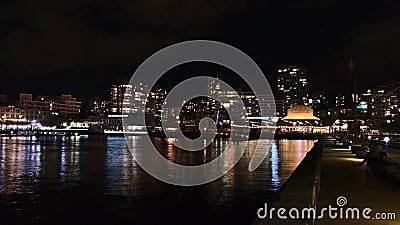Beautiful night view of The Shipyards, a neighborhood in North Vancouver, with jetty and illuminated buildings. Editorial Stock Photo