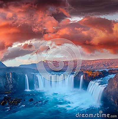 Mystical morning view of Godafoss waterfall with red clouds above. Stock Photo