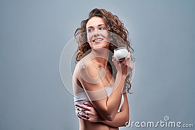 Beautiful nourished woman holding cream for her skin Stock Photo