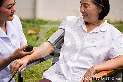 Nurse doing pressure measuring for female patient at the hospital park Stock Photo