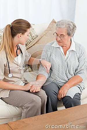 Beautiful nurse taking the pulse of her patient Stock Photo