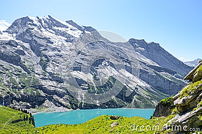 Beautiful Oeschinensee lake near Kandersteg in Switzerland. Turquoise lake surrounded by steep snow-capped mountains. Popular Stock Photo