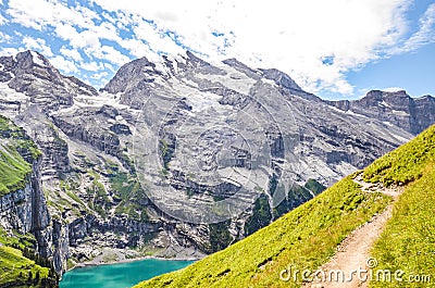 Beautiful Oeschinensee lake near Kandersteg in Switzerland. Turquoise lake surrounded by steep mountains and rocks. Popular travel Stock Photo