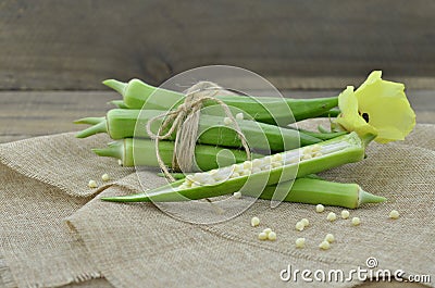 Beautiful okra flower with fruit on wooden background Stock Photo