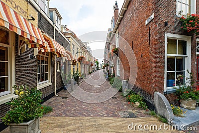 Beautiful old alley with flowers in the old city center of Delft, the Editorial Stock Photo