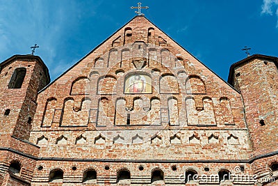 A beautiful old fortress church made of red brick against a blue sky background. A high impregnable fortress with iron crosses on Stock Photo