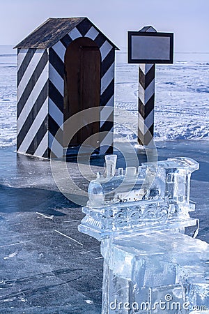 Beautiful old steam locomotive made of ice on the background of an old watchtower. Stock Photo