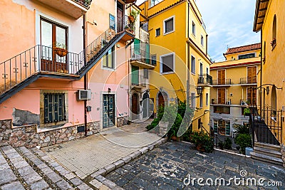 Beautiful old town of Taormina with small streets, flowers. Architecture with archs and old pavement in Taormina. Colorful narrow Stock Photo