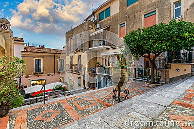 Beautiful old town of Taormina with small streets, flowers. Architecture with archs and old pavement in Taormina. Colorful narrow Stock Photo