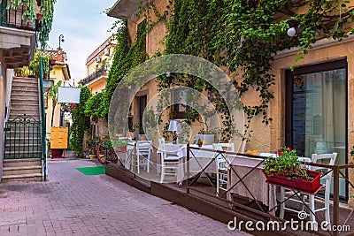 Beautiful old town of Taormina with small streets, flowers. Architecture with archs and old pavement in Taormina. Colorful narrow Stock Photo