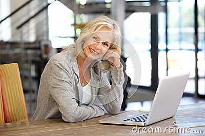 Beautiful older woman working laptop computer indoors Stock Photo