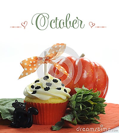 Beautiful orange Halloween theme cupcake with seasonal flowers and decorations for the month of October Stock Photo