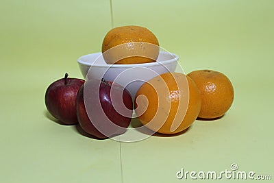 Beautiful oranges and apple on bowl Stock Photo
